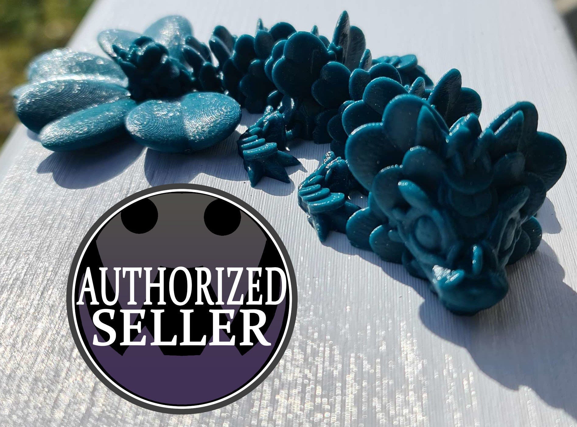 Blue 3D printed dragon toy on white surface with 'Authorized Seller' badge overlay