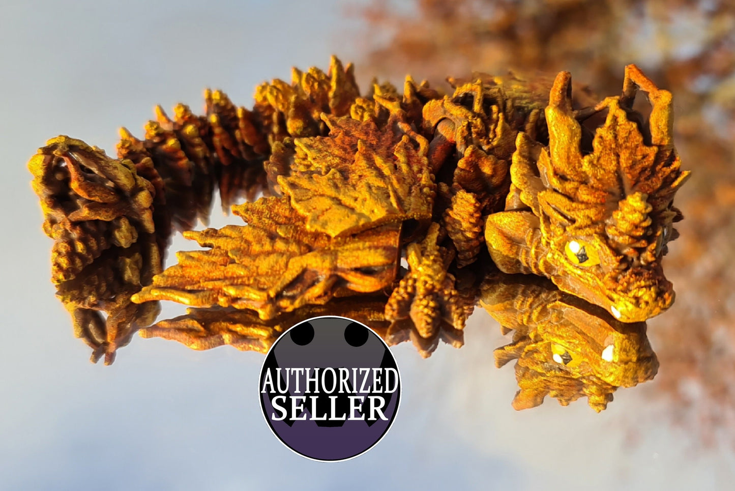 Hand-painted autumn leaf dragon miniature figurine with vibrant orange details, reflection visible