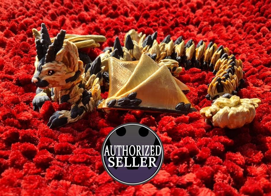 Handmade polymer clay dragon figurine with gold and black details on red textured surface