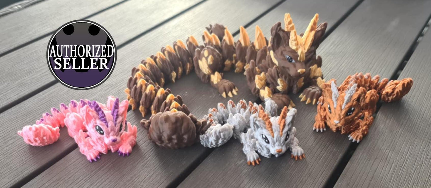 Handcrafted dragon figurines in various colors on wood surface, authorized seller badge
